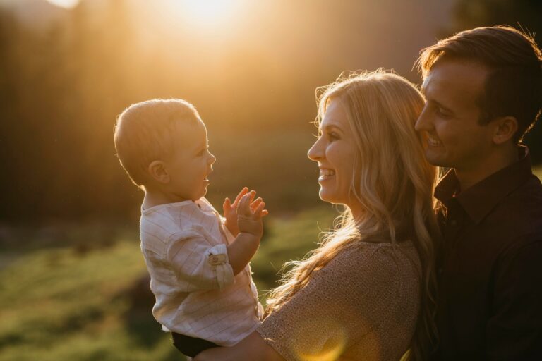 Happy family with little son outdoors at sunset